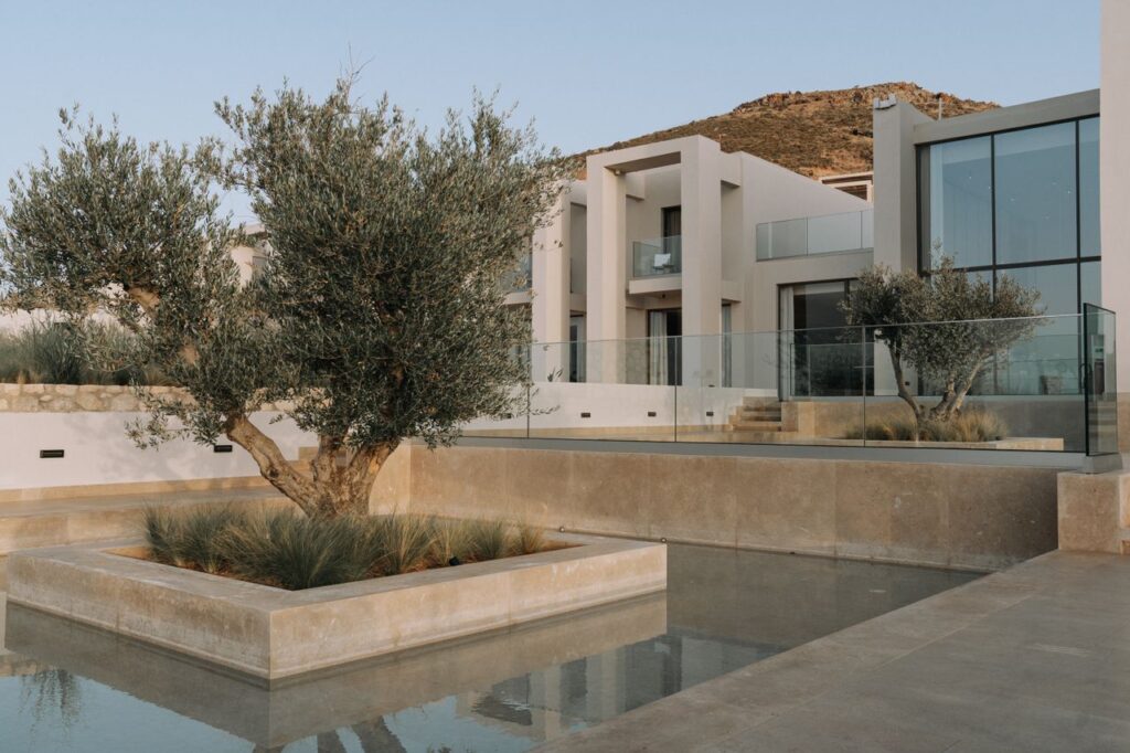 The Art of Drawing Readers In: Your attractive post title goes here Modern luxury house exterior with glass facade, landscaped garden, and water feature.