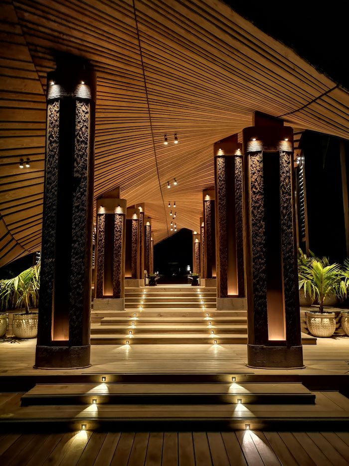 Elegant illuminated staircase with intricate columns at night, offering a majestic architectural view.